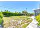 The lush, green, and well-maintained lawn in backyard is surrounded by trees and hedges at 305 E Wentworth Cir, Englewood, FL 34223