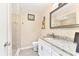 Elegant bathroom featuring a granite countertop vanity and tiled walk-in shower at 305 E Wentworth Cir, Englewood, FL 34223