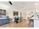 Dining area with wood floors, teal chairs, a stylish cabinet, and easy access to the kitchen at 305 E Wentworth Cir, Englewood, FL 34223