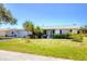 Well-maintained single-story home featuring tidy landscaping, mature palms, and a welcoming front entrance for guests at 305 E Wentworth Cir, Englewood, FL 34223