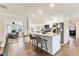 Kitchen with granite island with bar seating, stainless steel appliances and view to den at 305 E Wentworth Cir, Englewood, FL 34223