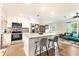 Kitchen with granite island with bar seating, stainless steel appliances, and light wood flooring at 305 E Wentworth Cir, Englewood, FL 34223