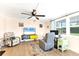 Living room with ceiling fan, bright windows, comfortable seating, and light wood flooring at 305 E Wentworth Cir, Englewood, FL 34223