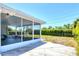 Enjoy the outdoors from this screened patio with concrete flooring and adjacent grassy yard at 305 E Wentworth Cir, Englewood, FL 34223