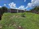 This image shows the backyard and back of the home with a shed and patio at 3157 Crestwood Dr, Port Charlotte, FL 33952