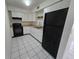 Functional kitchen with white cabinets, black appliances, and tile flooring at 3157 Crestwood Dr, Port Charlotte, FL 33952