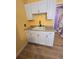 Close-up of a kitchen sink with white cabinetry and yellow walls at 3157 Crestwood Dr, Port Charlotte, FL 33952