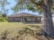 Spacious backyard featuring a large, mature tree and a screened-in patio with outdoor seating at 3695 Waffle Ter, North Port, FL 34286