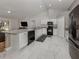 Modern kitchen featuring white cabinetry, black appliances, granite countertops, and tile flooring at 3695 Waffle Ter, North Port, FL 34286