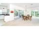 Dining space with seating, slider to screened porch and a peek into the kitchen at 3929 Cape Haze Dr # 101, Rotonda West, FL 33947