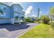 Coastal condo building with blue siding, tropical landscaping, and private garage entrances at 3929 Cape Haze Dr # 101, Rotonda West, FL 33947