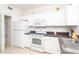 Functional kitchen with white appliances, ample cabinet space, and tile flooring at 3929 Cape Haze Dr # 101, Rotonda West, FL 33947