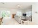 Open living room with abundant natural light from large windows and ceiling fan for comfort at 3929 Cape Haze Dr # 101, Rotonda West, FL 33947