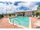 Community pool featuring sun loungers, a pool house, and a brick paver deck for relaxing by the water at 3929 Cape Haze Dr # 101, Rotonda West, FL 33947