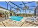 Inviting pool with screened-in enclosure, palm trees, and lounge chairs at 500 Green Dolphin S Dr, Placida, FL 33946