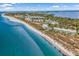 An aerial view showcases the property next to the beach and other coastal homes at 5000 Gasparilla Rd # 8B, Boca Grande, FL 33921