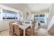 Open dining room that flows into the living room with floor-to-ceiling windows and beach views at 5000 Gasparilla Rd # 8B, Boca Grande, FL 33921