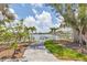 Lush backyard features a picturesque view of the water, complemented by swaying palms and mature trees at 565 Green Dolphin S Dr, Placida, FL 33946