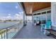Large covered balcony with seating area, overlooking a waterfront and adjacent pool at 565 Green Dolphin S Dr, Placida, FL 33946