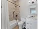 Well-lit bathroom with a shower-tub combo, tiled walls, and modern vanity at 565 Green Dolphin S Dr, Placida, FL 33946