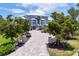 Elegant home with a brick paved driveway, lush landscaping, and grand facade at 565 Green Dolphin S Dr, Placida, FL 33946