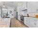 Well-lit kitchen featuring white cabinets, stainless steel appliances, and wood flooring at 565 Green Dolphin S Dr, Placida, FL 33946