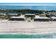 Aerial view of beachfront condos with pool, bordering turquoise water, and sandy beaches at 5700 Gulf Shores Dr # B-137, Boca Grande, FL 33921