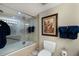 Bright bathroom featuring a shower with glass doors, a toilet, and a vanity with a marble countertop and oval mirror at 5700 Gulf Shores Dr # B-137, Boca Grande, FL 33921