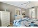 Charming bedroom with view into ensuite bathroom, dresser, nightstand, and starfish-themed comforter and throw pillows at 5700 Gulf Shores Dr # B-137, Boca Grande, FL 33921