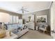 Light and airy bedroom with a ceiling fan, a large mirror over a dresser, a sitting chair, and a painting of hibiscus flowers at 5700 Gulf Shores Dr # B-137, Boca Grande, FL 33921