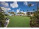 Expansive lawn with tropical landscaping, palm trees, and a clear view of the building exterior and beach access at 5700 Gulf Shores Dr # B-137, Boca Grande, FL 33921