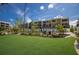 Beautiful building exterior with lush landscaping, palm trees, green lawn, and an inviting outdoor patio area at 5700 Gulf Shores Dr # B-137, Boca Grande, FL 33921
