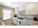 Well-lit kitchen with white cabinets, modern appliances, and neutral countertops at 5700 Gulf Shores Dr # B-137, Boca Grande, FL 33921