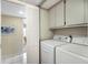Practical laundry room with washer, dryer, and storage cabinets for convenience at 5700 Gulf Shores Dr # B-137, Boca Grande, FL 33921