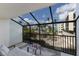 Screened-in patio featuring beach and palm tree views, a loveseat, a small table, and a leafy rug at 5700 Gulf Shores Dr # B-137, Boca Grande, FL 33921