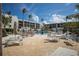 Inviting pool area with lounge chairs, tables, umbrellas, and a scenic view of the surrounding property at 5700 Gulf Shores Dr # B-137, Boca Grande, FL 33921