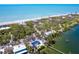 Aerial view of a beachfront property surrounded by lush greenery with beach access and waterfront at 6430 Manasota Key Rd, Englewood, FL 34223