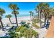 Gorgeous backyard featuring sandy landscape, lush green vegetation, and beautiful palm trees at 6430 Manasota Key Rd, Englewood, FL 34223