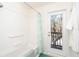 White bathroom with tub/shower, mint-themed curtain and outdoor views from the adjacent outdoor patio at 6430 Manasota Key Rd, Englewood, FL 34223