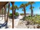 Scenic stone path lined with lush greenery and palm trees leads to the sandy beach and tranquil ocean views at 6430 Manasota Key Rd, Englewood, FL 34223
