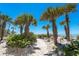 Charming beach path lined with tropical vegetation and palm trees leads to the serene ocean at 6430 Manasota Key Rd, Englewood, FL 34223