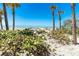 Picturesque view of the beach with lush vegetation leading to the sandy shore and crystal-clear ocean waters at 6430 Manasota Key Rd, Englewood, FL 34223
