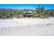 Beachfront home surrounded by lush palm trees, offering stunning ocean views and direct access to the sandy beach at 6430 Manasota Key Rd, Englewood, FL 34223