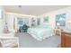 Sunlit bedroom with soothing blue accents, desk and chair, offering a peaceful retreat at 6430 Manasota Key Rd, Englewood, FL 34223