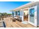 Exterior view of a spacious wood deck with outdoor seating and ocean views, and access to the living area at 6430 Manasota Key Rd, Englewood, FL 34223