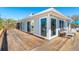 Beautiful home features large windows, outdoor seating area, and spacious wooden deck at 6430 Manasota Key Rd, Englewood, FL 34223