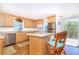 Bright kitchen featuring wood floors, an island with seating, stainless steel appliances, and an adjacent breakfast nook at 6430 Manasota Key Rd, Englewood, FL 34223