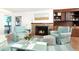Cozy living room with stone fireplace, built-in shelves, and access to an outdoor deck with a beach view at 6430 Manasota Key Rd, Englewood, FL 34223