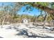 Charming white outbuilding surrounded by trees and nature, creating a serene escape at 6430 Manasota Key Rd, Englewood, FL 34223