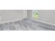 This bedroom features modern gray floors, white trim, a ceiling fan, a window, and closet with doors at 8270 Cook Ct, Port Charlotte, FL 33981